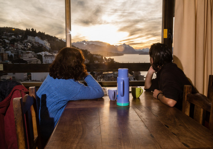 dos huespedes mirando el atardecer desde la mesa del living